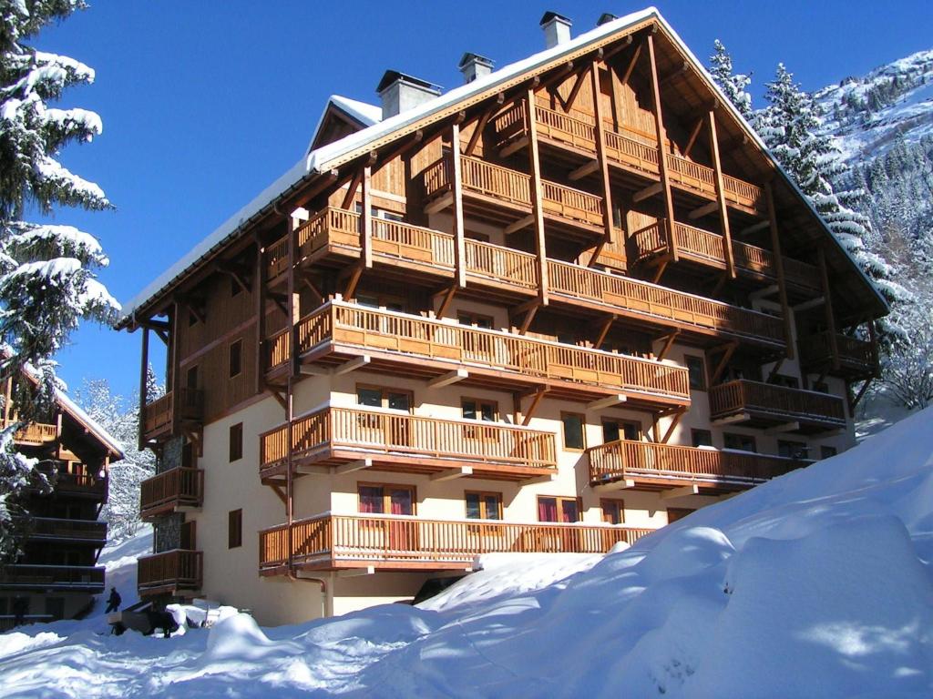 OzApartment on the slopes in the big ski area Grandes Rousses的前面有雪的大建筑
