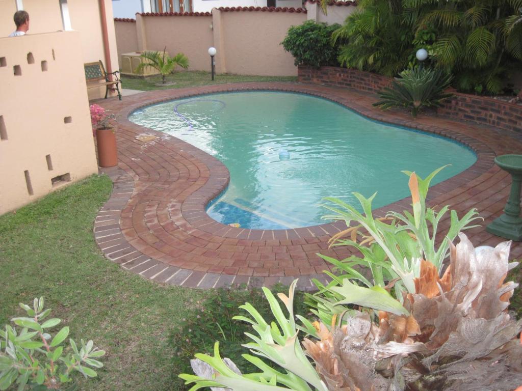 马盖特Swallows Nest B&B的环绕着酒店的砖砌通道的游泳池