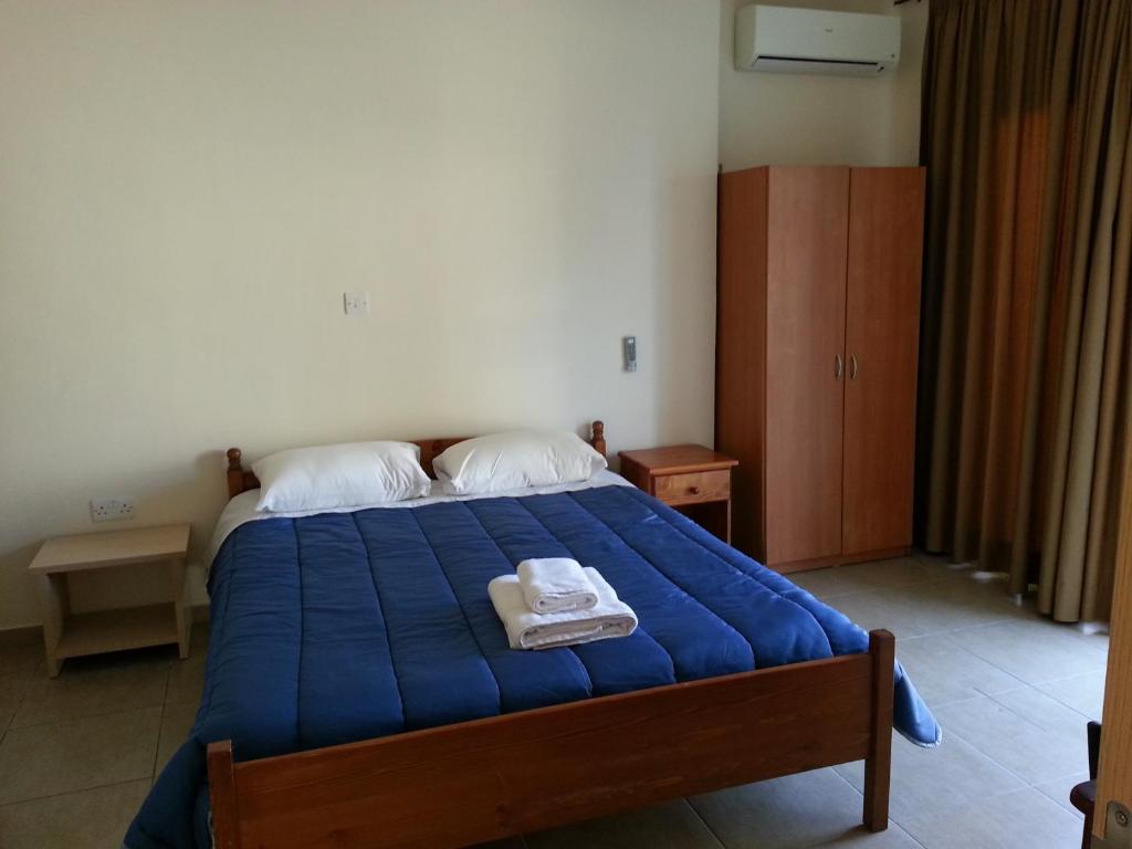 拉纳卡圣拉萨洛斯公寓的一间卧室配有蓝色的床和2条毛巾