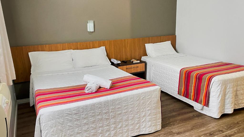 伊达贾伊Itajaí Express Residence的两张位于酒店客房的床,配有毛巾