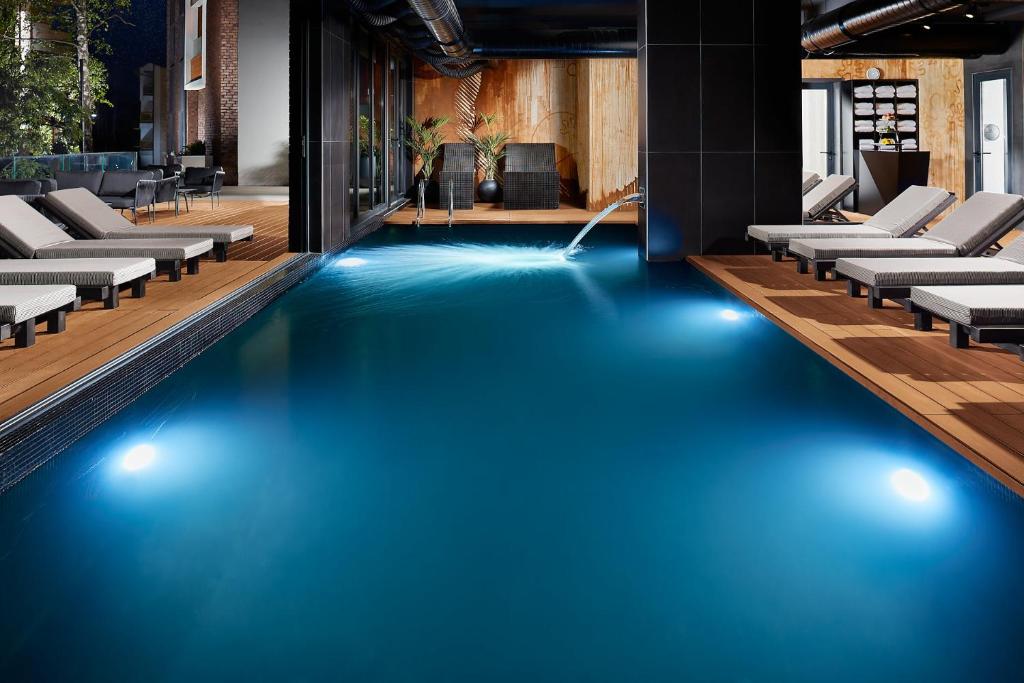 兹拉蒂博尔21st Century Zlatibor Residence, Spa & Wellness by Adora的大楼内的一个蓝色海水游泳池