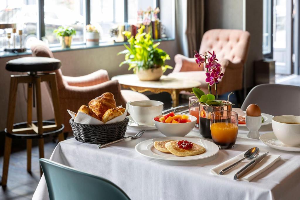 巴黎法布里克酒店的一张桌子,上面有白色的桌布,上面有早餐食品