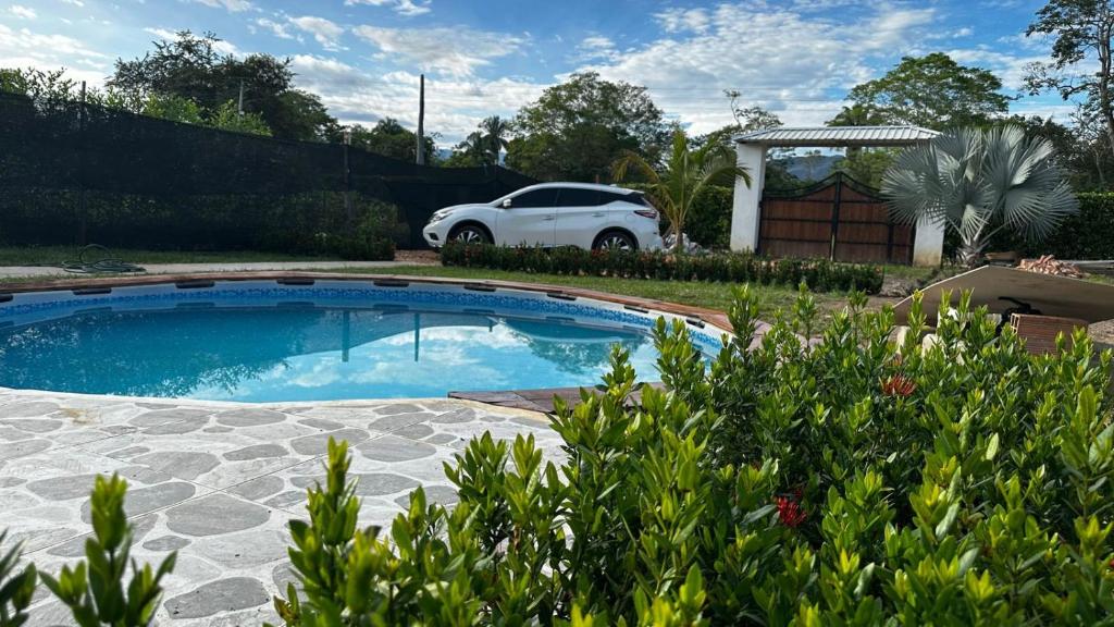 卡门阿皮卡拉Casa bella de campo Wifi billar piscina bolirana !privado!的游泳池旁的白色汽车