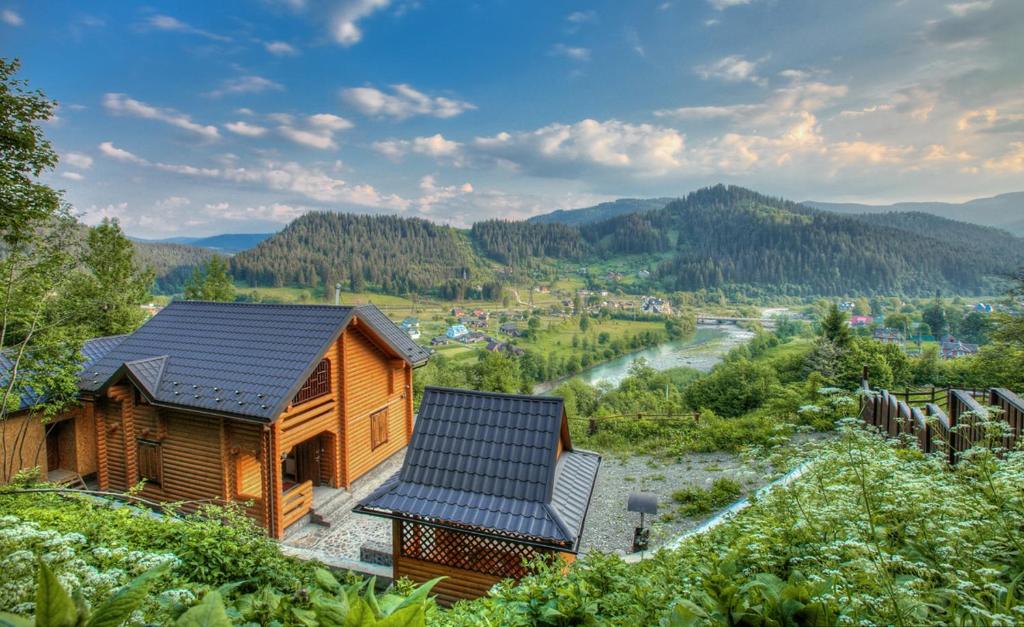 亚列姆切Cottage Goyra的一座带太阳能屋顶和河流的木屋