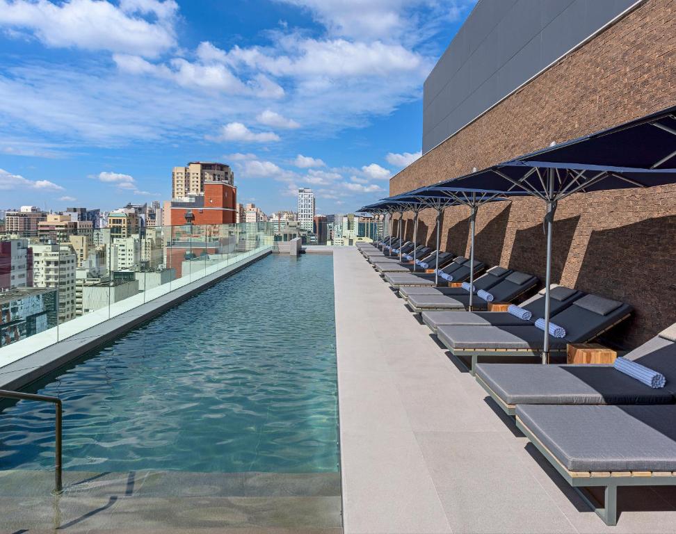 圣保罗Hotel Fasano Sao Paulo Itaim的一座带躺椅的建筑屋顶上的游泳池