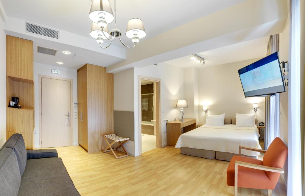 比雷埃夫斯菲迪亚斯比雷埃弗斯酒店的配有一张床和一台平面电视的酒店客房