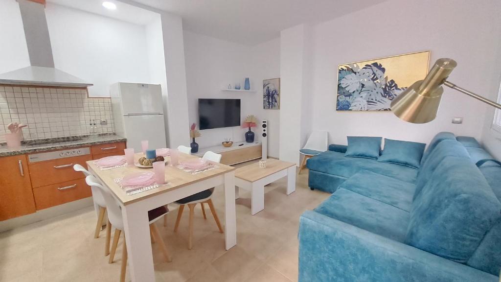 塞维利亚Apartamentos TrianaSol的客厅配有蓝色的沙发和桌子