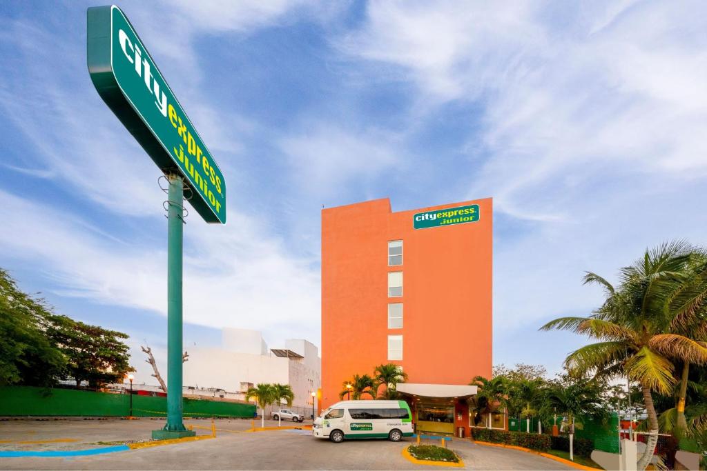 卡门城City Express Junior by Marriott Ciudad del Carmen的建筑前的绿色街道标志