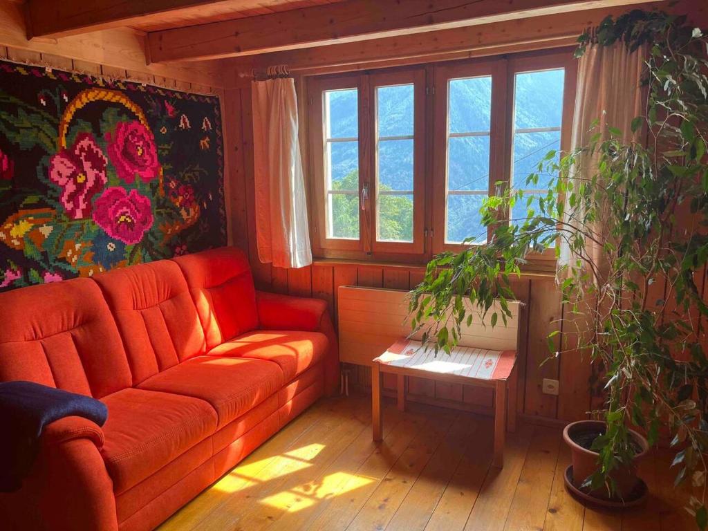 法伊多Appartamento accogliente di montagna a Cavagnago的客厅设有红色的沙发和窗户。