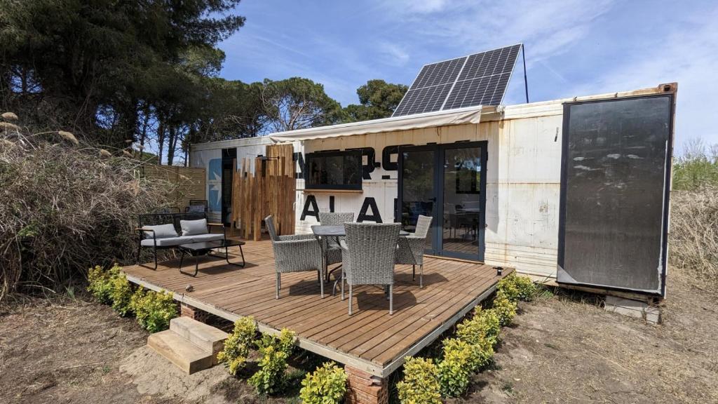 卡斯特尔德费尔斯CoolTainer retreat: Sustainable Coastal forest Tiny house near Barcelona的甲板上设有太阳能电池板的房子