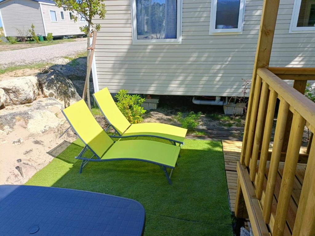 雷日卡普费雷mobil-home neuf 4-6 places camping Siblu les viviers的坐在甲板上的一双黄色椅子
