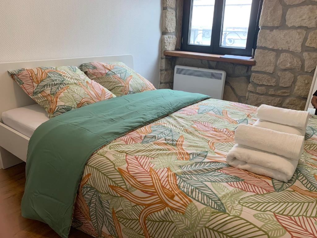 阿尔泽特河畔埃施Private Room in the City Centre的一张带色彩缤纷的被子和毛巾的床