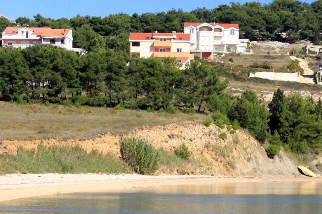 维拉斯奇Apartments by the sea Vlasici, Pag - 9324的海滩旁小山上的一群房子