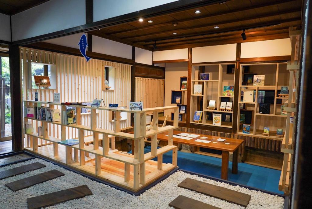 Sanukiうみの図書館的一间设有书店的房间,配有木桌