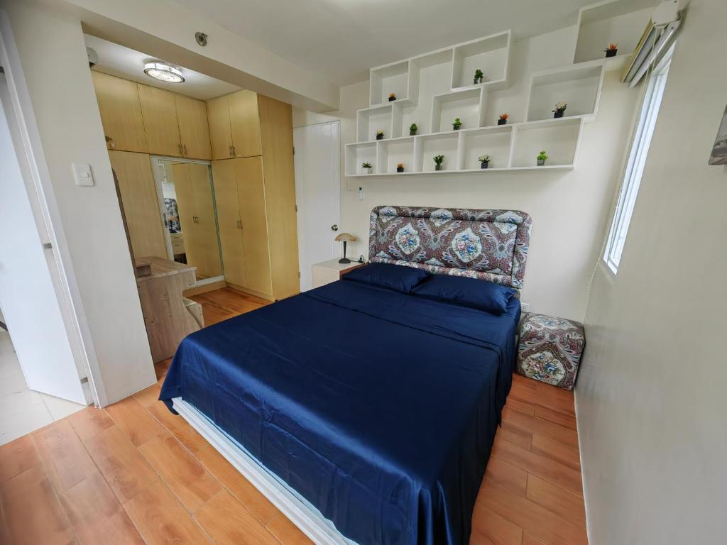 达沃市Casa Felicitas 1的一间小卧室,配有蓝色的床和椅子