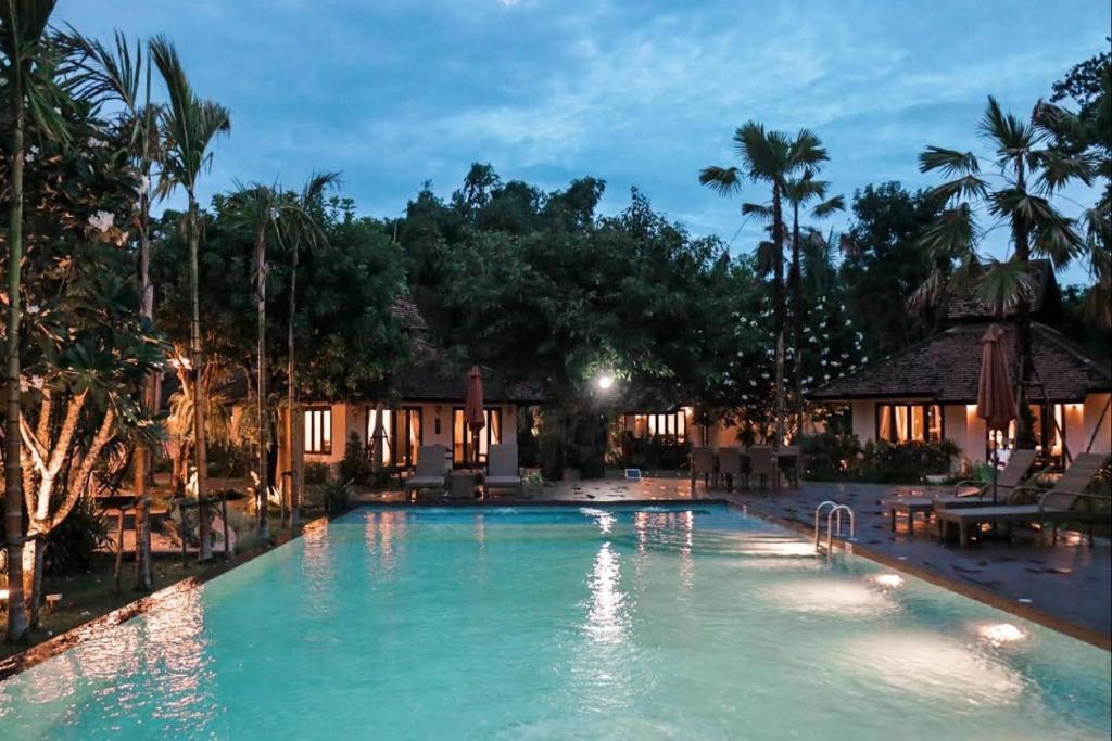清迈Le Baan Thai Boutique Villa的夜间在度假村的游泳池