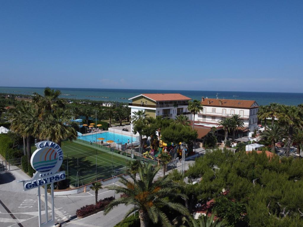 滨海库普拉Camping Villaggio Calypso的享有带游泳池和海洋的度假胜地的景致