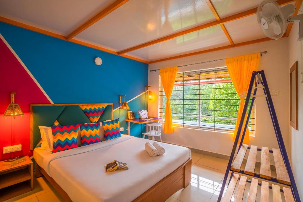 马迪凯里goSTOPS Coorg的一间卧室设有一张带梯子和窗户的床