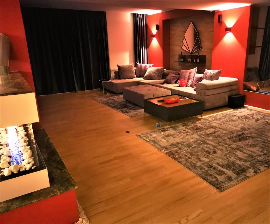 Remetea MareNETFLIX & CHILL的客厅设有红色的墙壁和沙发。