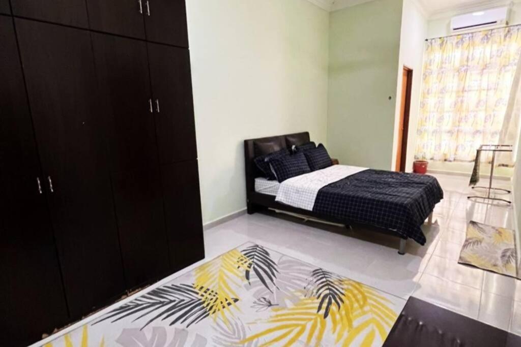 巴西富地Kayak D'bali Homestay的一间卧室配有一张黑色和黄色毯子的床