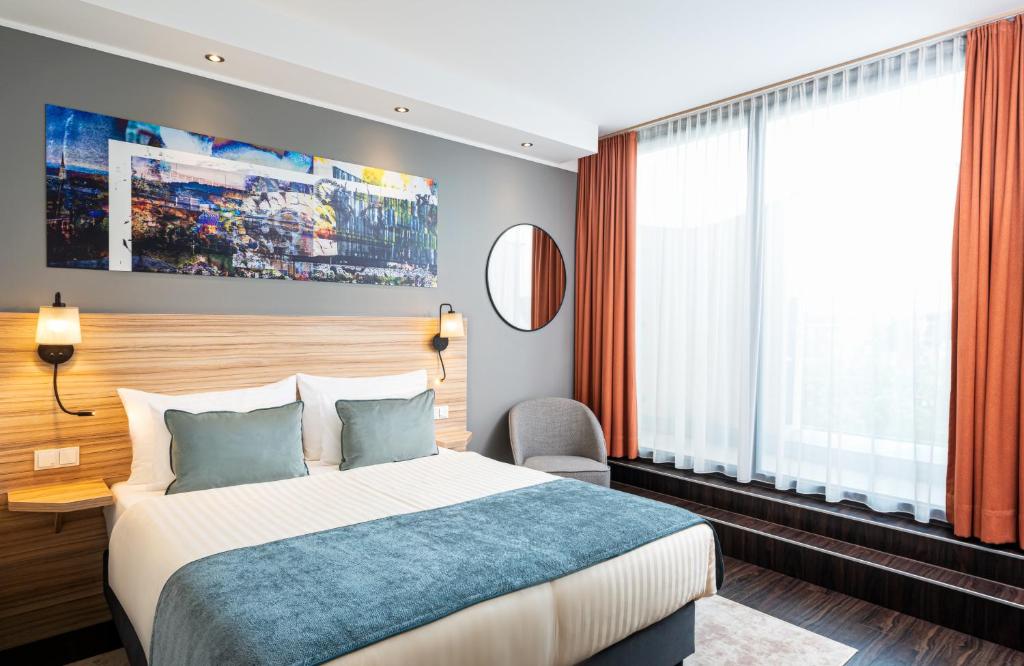 林茨Leonardo Boutique Hotel Linz City Center的酒店客房设有一张床和一个大窗户
