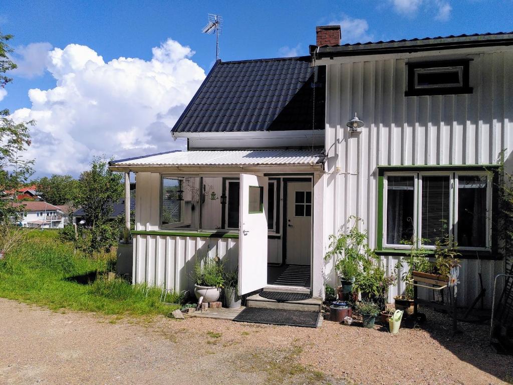 HenånLägenhet naturnära i Henån的一间黑色屋顶的白色小房子