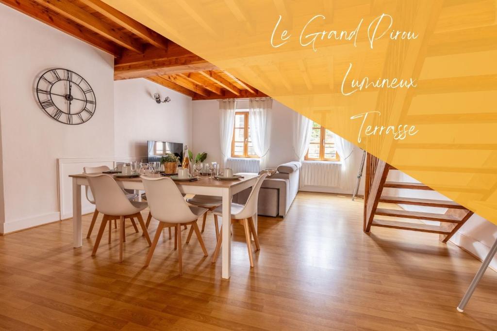 蒂耶尔Le Grand Pirou # Lumineux # Halte Auvergne的一间带桌椅和时钟的用餐室