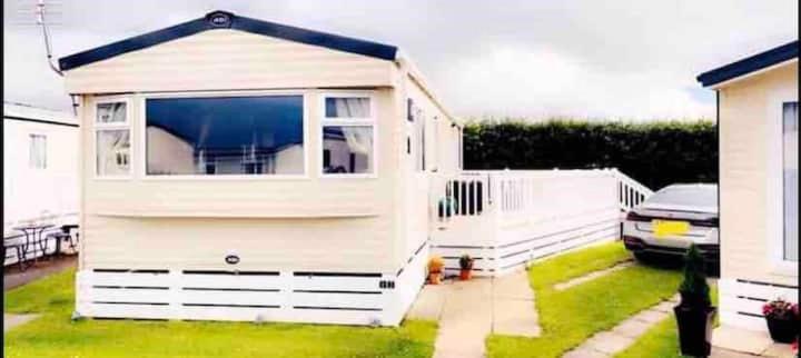 卡纳芬Beautiful 3 bed Static Caravan with Snowdon views in Caernarfon的院子中带窗户的小白色棚子