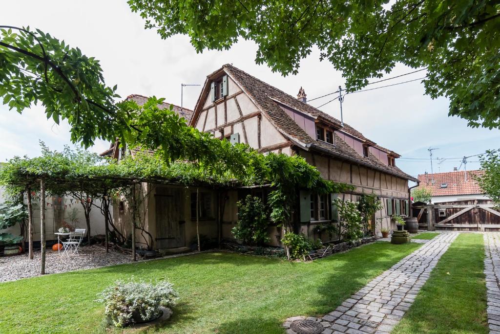伊尔基希-格拉芬斯塔登Maison Alsacienne 6p的一座带绿色庭院的古老房子