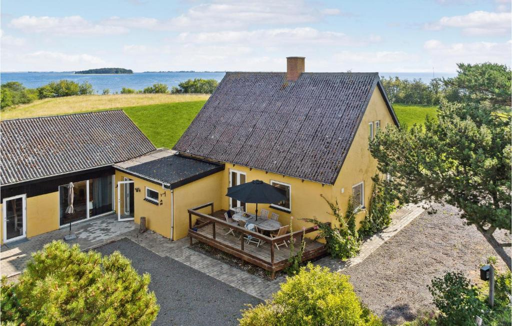 班霍尔姆Awesome Home In Bandholm With House Sea View的享有黄色房屋的空中景致,设有天井。
