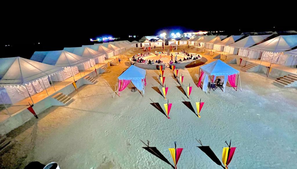 斋沙默尔Golden Fort Resort的一群晚上在海滩上放风筝的帐篷