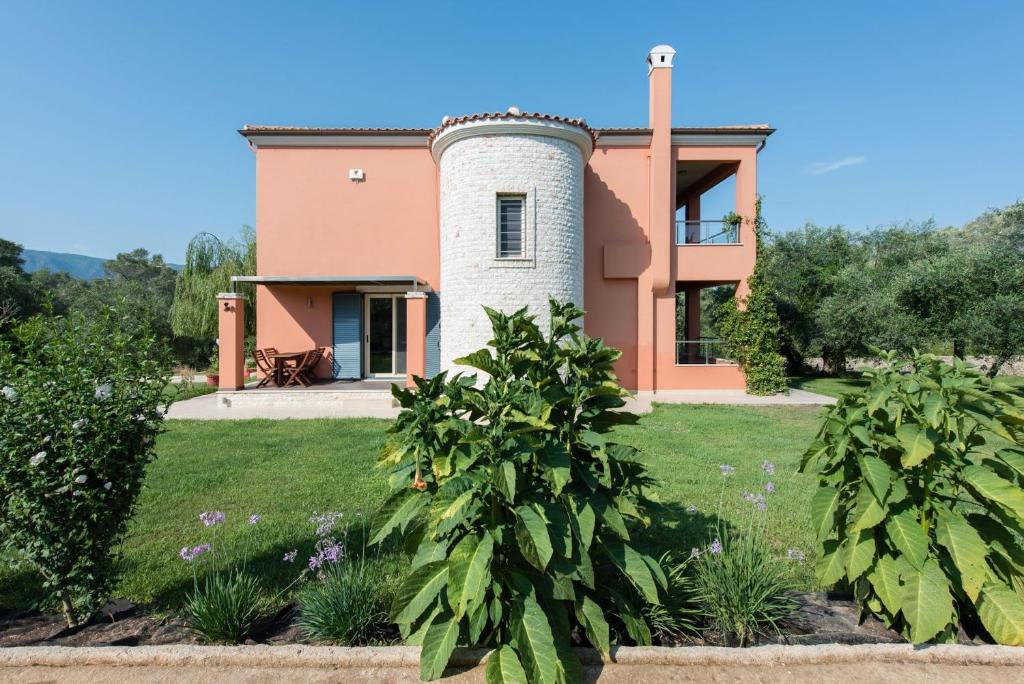 DafnilaContemporary Corfu Retreat - 3 Bedrooms - Villa Girasole - Artful Decor - Lush Garden - Tranquil Setting的院子中间有塔楼的房子