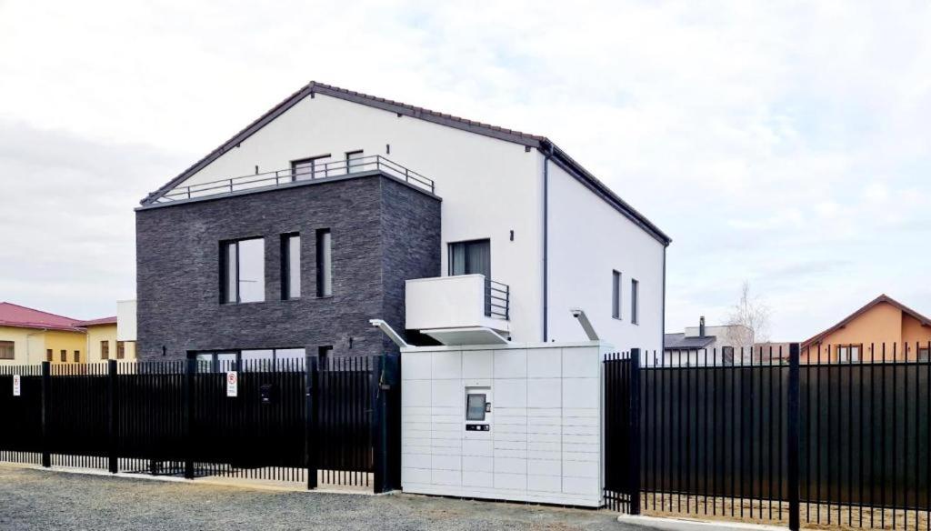 DumbrăviţaArmins's Residence 2 - Villa的黑色和白色的房屋,设有黑色的围栏