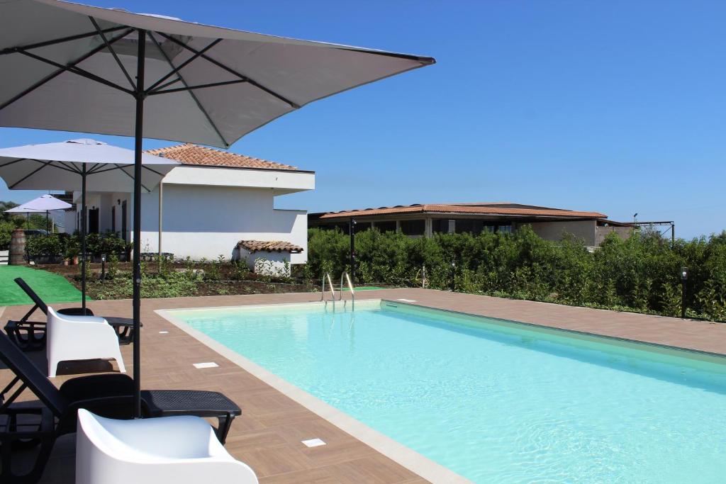 加里Casa vacanze - Orto dei Limoni的房屋旁的游泳池配有椅子和遮阳伞