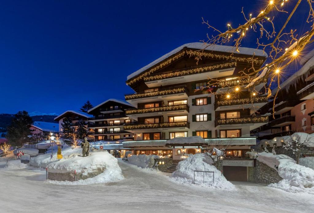 克洛斯特斯瑟纽斯Seven Alpina Boutique Hotel的一座大建筑物,在晚上下雪