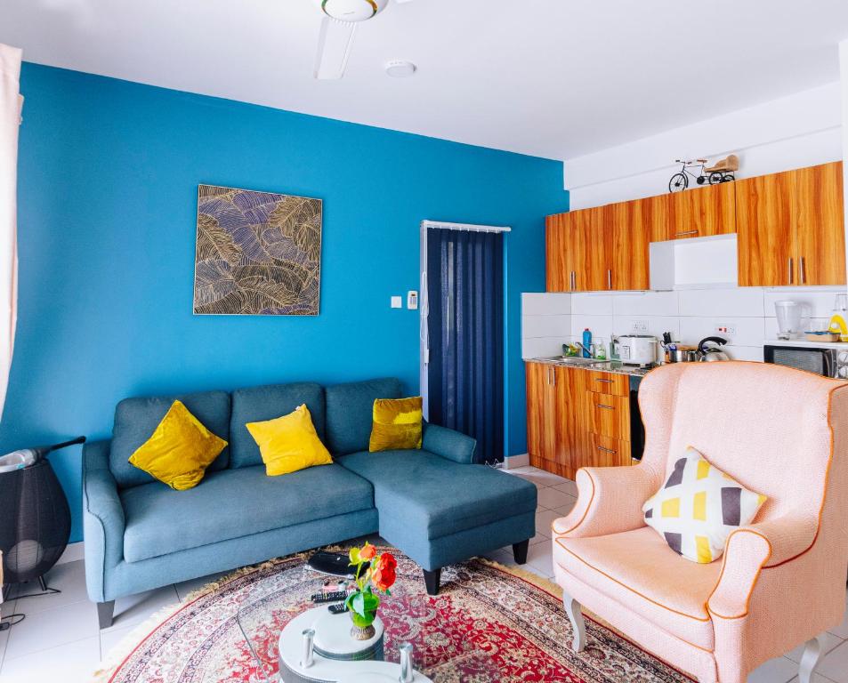 FumbaFumbatown Cozy 1 bed Apartment的蓝色的客厅配有沙发和椅子