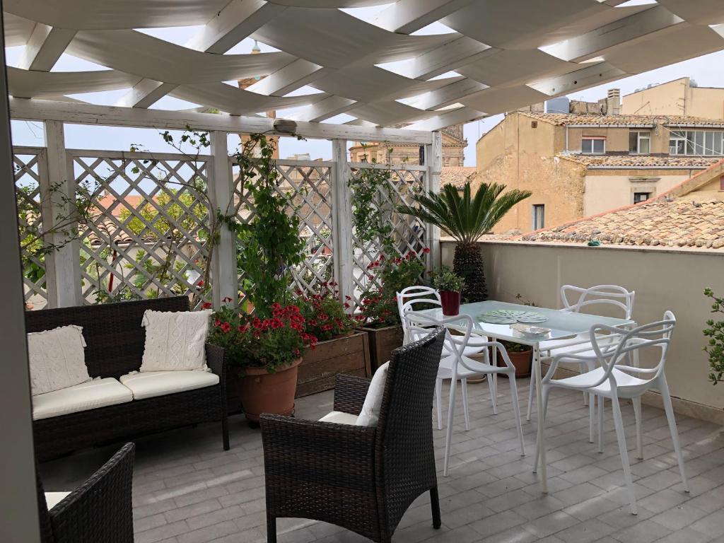 卡尔塔吉罗Attico Da Rosa con vista spettacolare a 360 gradi的阳台的天井配有桌椅