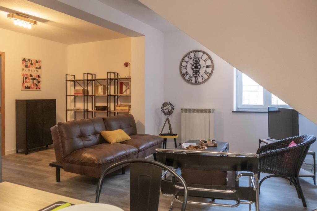法勒斯堡Nouveau - L'Harmony - Centre ville的客厅配有沙发和墙上的时钟