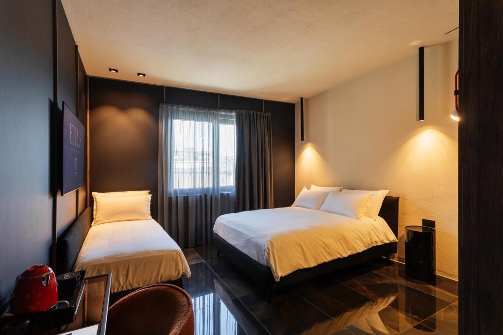 庞特卡格纳诺Etrus - Boutique Room & Rooftop的酒店客房设有两张床和窗户。