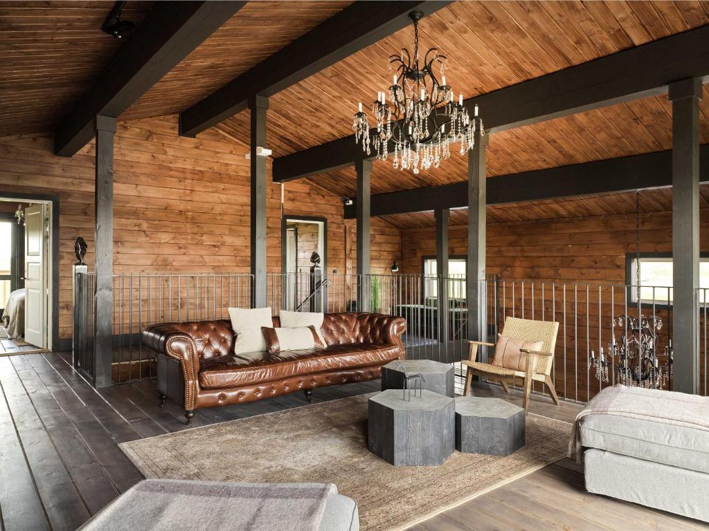 海拉Laxá Lodge的客厅配有真皮沙发和吊灯