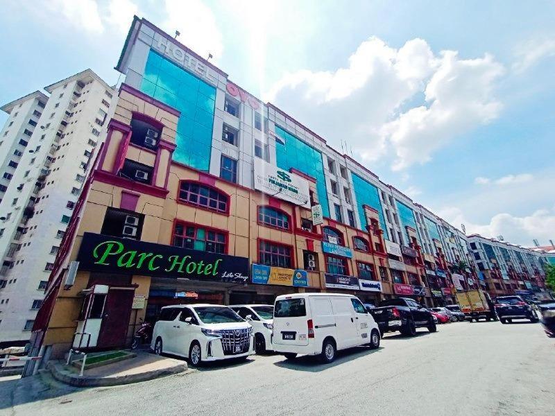 科塔达曼萨拉Parc Hotel Pelangi Damansara的停车场内停放汽车的大型建筑