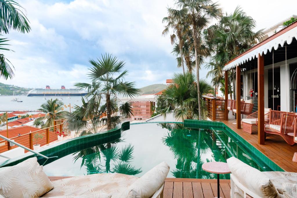 夏洛特阿马利亚The Pink Palm Hotel - Adults Only的一座棕榈树游泳池,享有水景