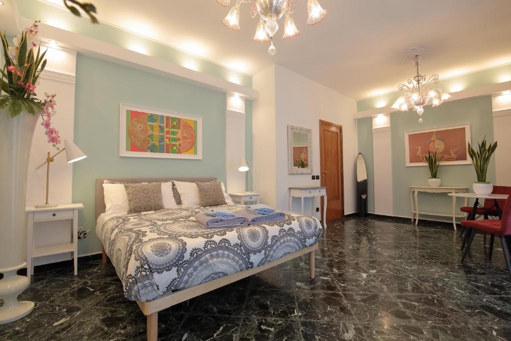 巴里L.T. BARI SUITE _ Locazioni Turistiche _的一间卧室配有一张床、两张桌子和一个吊灯。