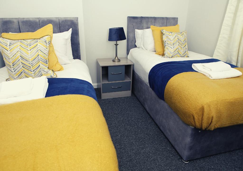 伦敦Must stay 3 Bedroom house near Greenwich and Blackheath- Ideal for families and contractors的黄色和蓝色的客房内的两张床