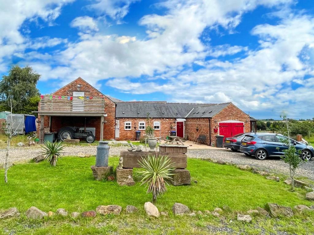 Trimdon GrangeQuaint 4 Bed Barn Conversion Barnhouse Starshinezz的前面有停车位的砖房