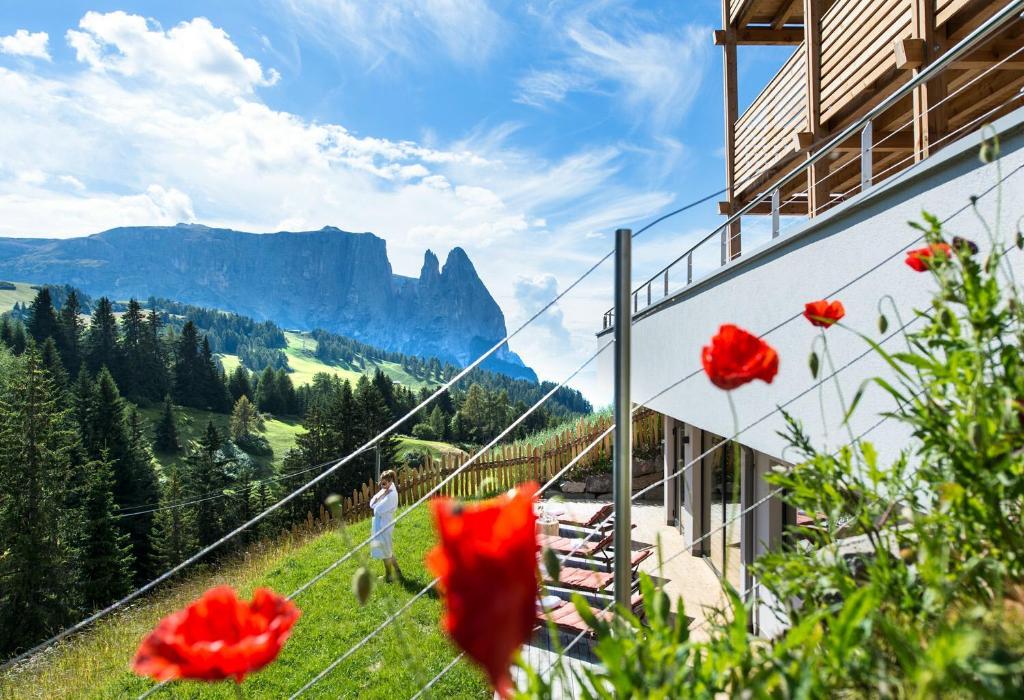 阿尔卑斯休斯山沙莱多洛米蒂酒店的站在山边,花红的人