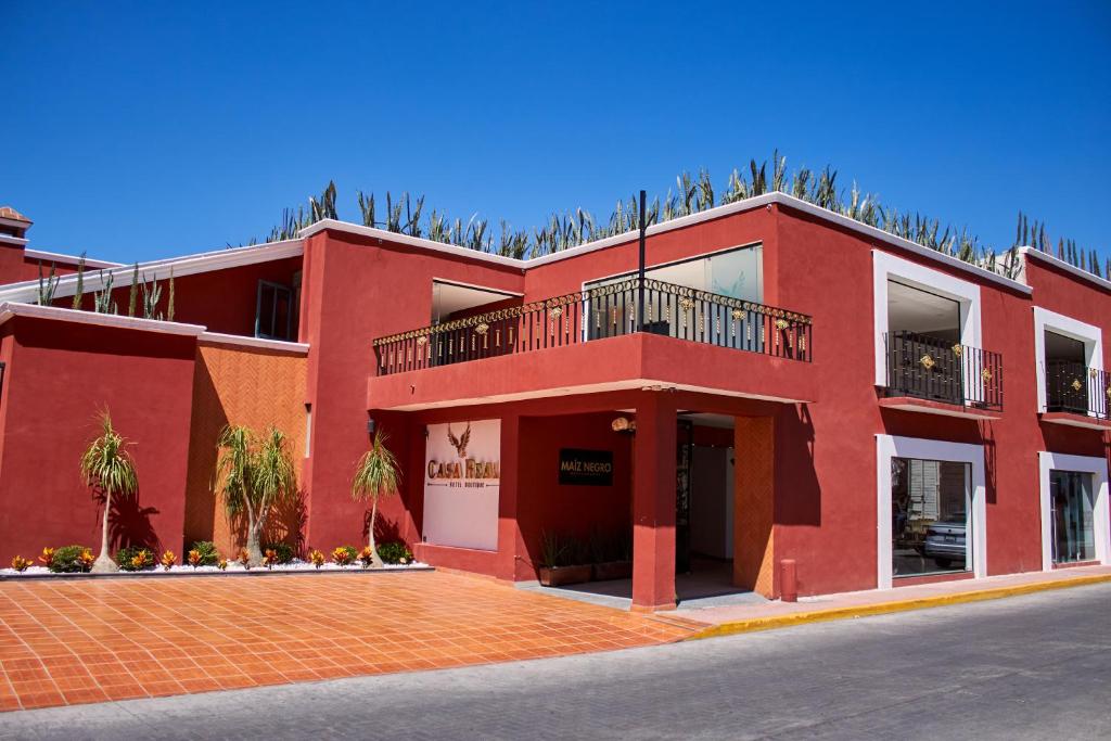 乔卢拉Hotel Casa Real Cholula的一座红色的建筑,上面设有一个阳台