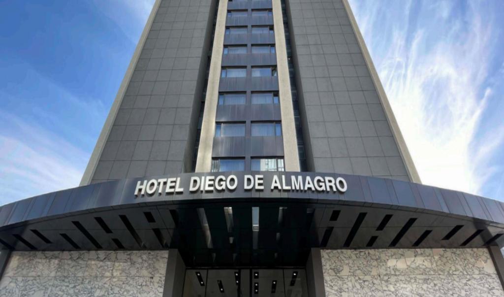 圣地亚哥圣地亚哥阿尔马格罗普罗维登酒店的一座高楼前方展示了一座阿尔伯克基酒店