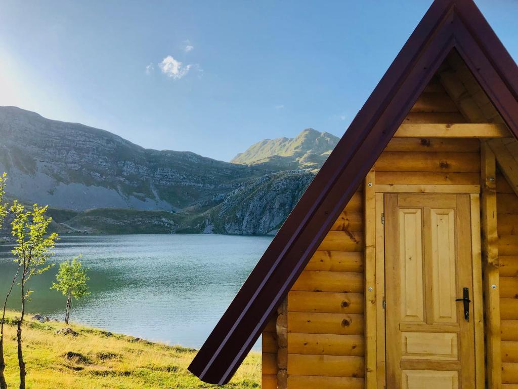 波德戈里察Kapetanovo Jezero Bungalov的湖前有门的小木屋