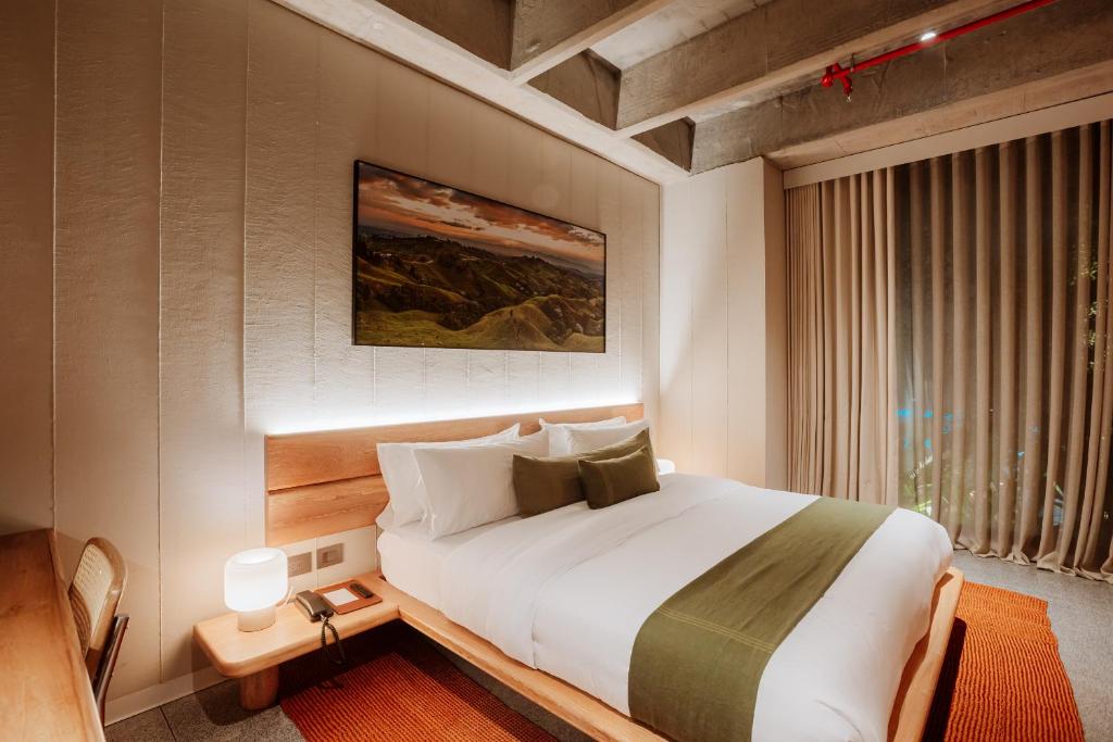 麦德林Hotel El Zarzo的一间卧室设有一张大床和一个窗户。